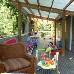 A porch with several children 's toys and furniture.
